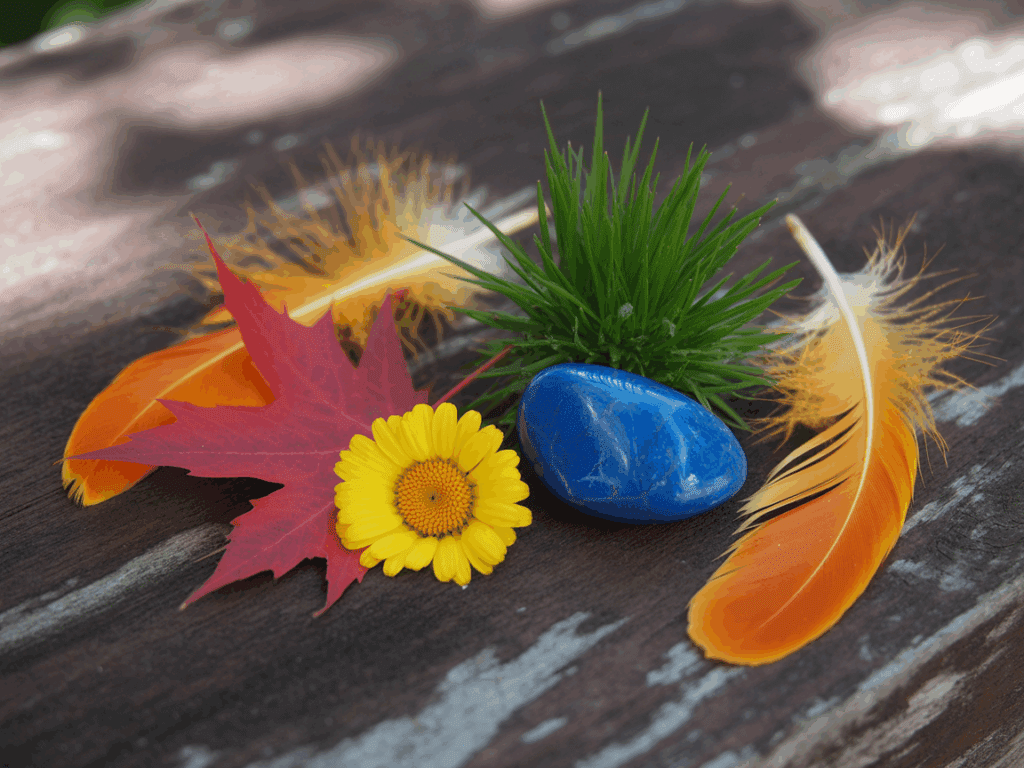 Verschiedene farbige Naturmaterialien (Blatt, Blume, Stein) arrangiert auf Holz – Fotoidee zur Farbwahrnehmung im Freien